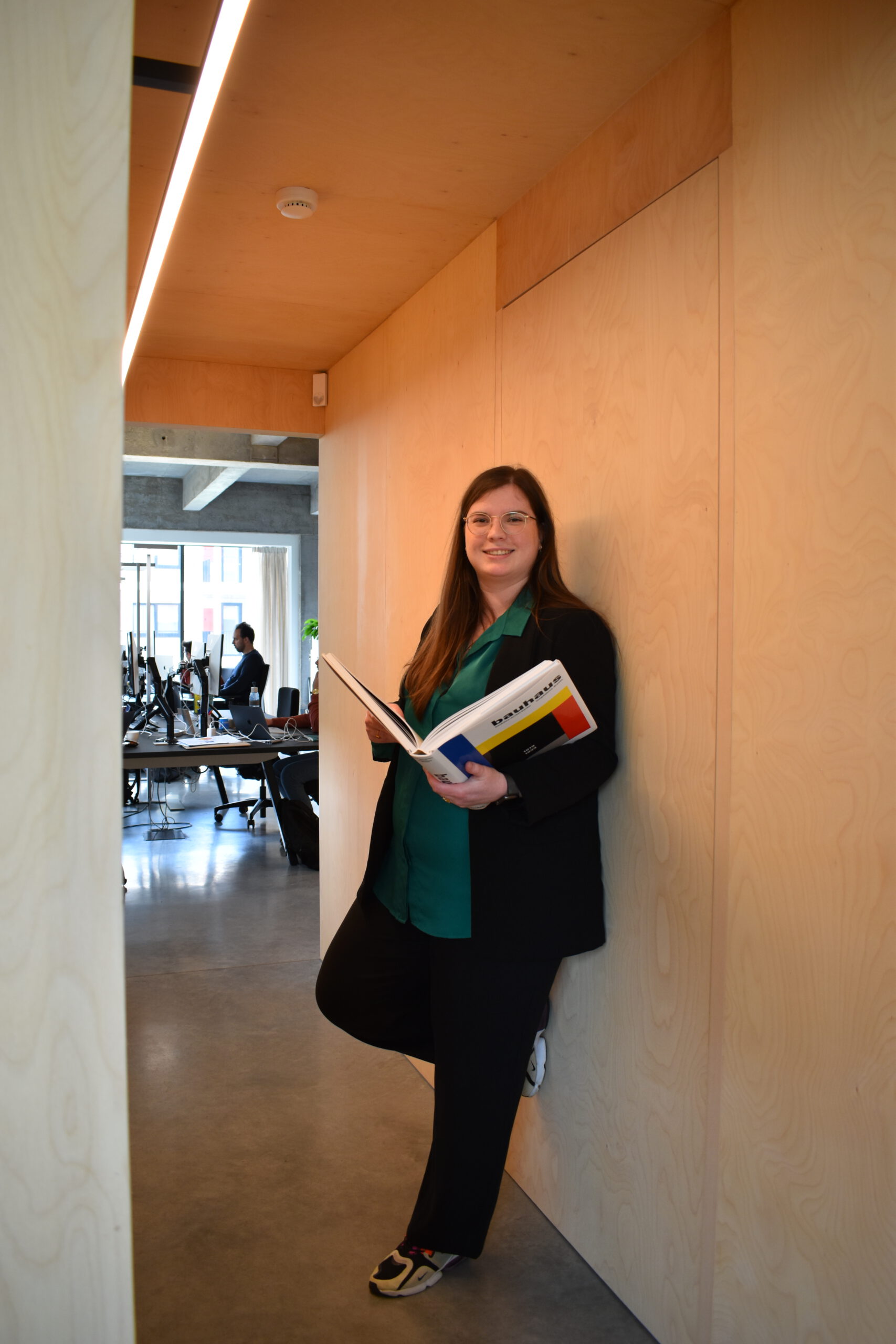 Eleni staat recht met een boek in haar handen